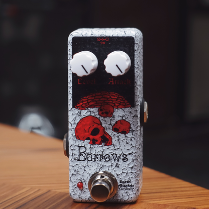 EarthQuaker Devices Guitar effects pedal caled Barrows with cracked texture and red skull design on a wooden surface.
